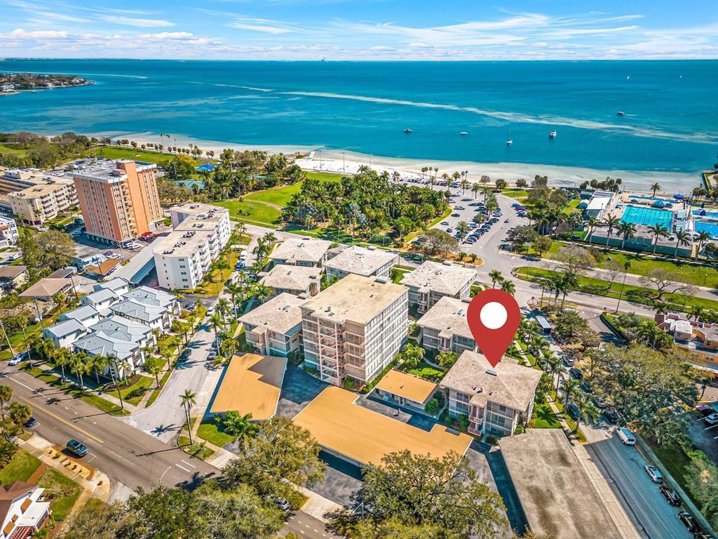 An aerial view shows a multi-story apartment complex near a beach and the ocean — 615 10TH AVENUE NE UNIT 1, ST PETERSBURG, FL