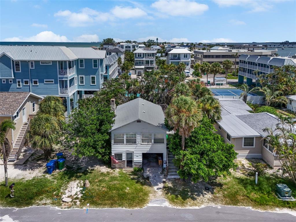 An aerial view shows a two-story house with a gray roof surrounded by palm trees — 104 10TH STREET S, BRADENTON BEACH, FL