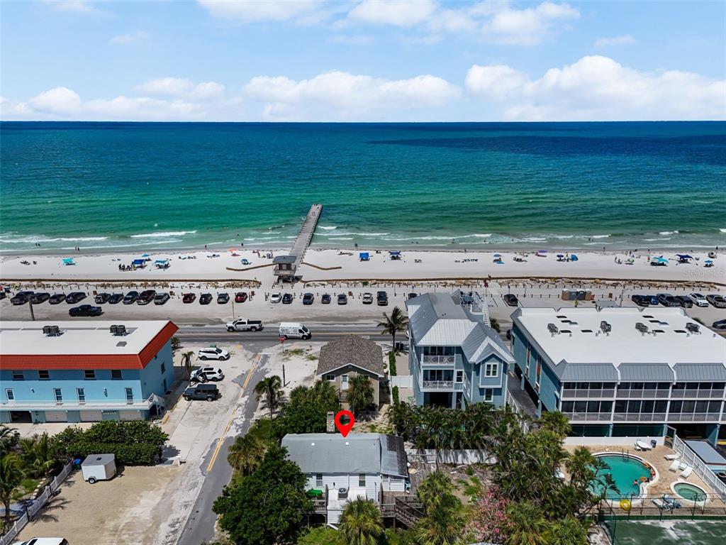 An aerial view shows a beach house with a red marker near the oceanfront — 104 10TH STREET S, BRADENTON BEACH, FL