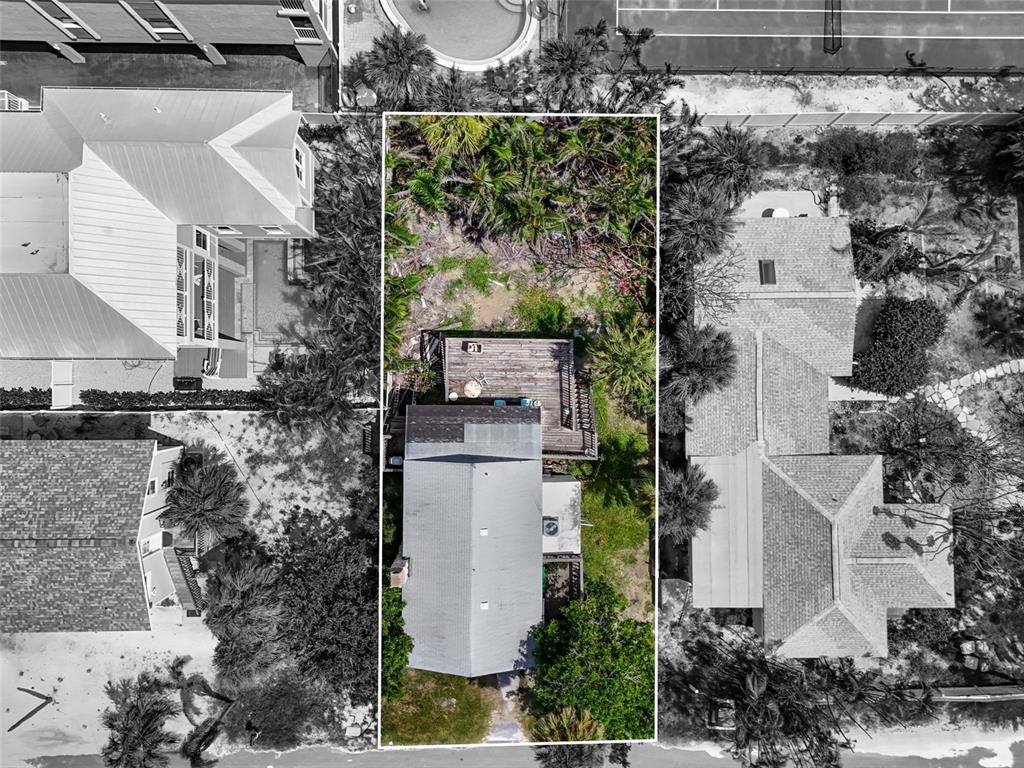 An aerial view shows a rectangular residential lot containing a house with a wooden deck — 104 10TH STREET S, BRADENTON BEACH, FL