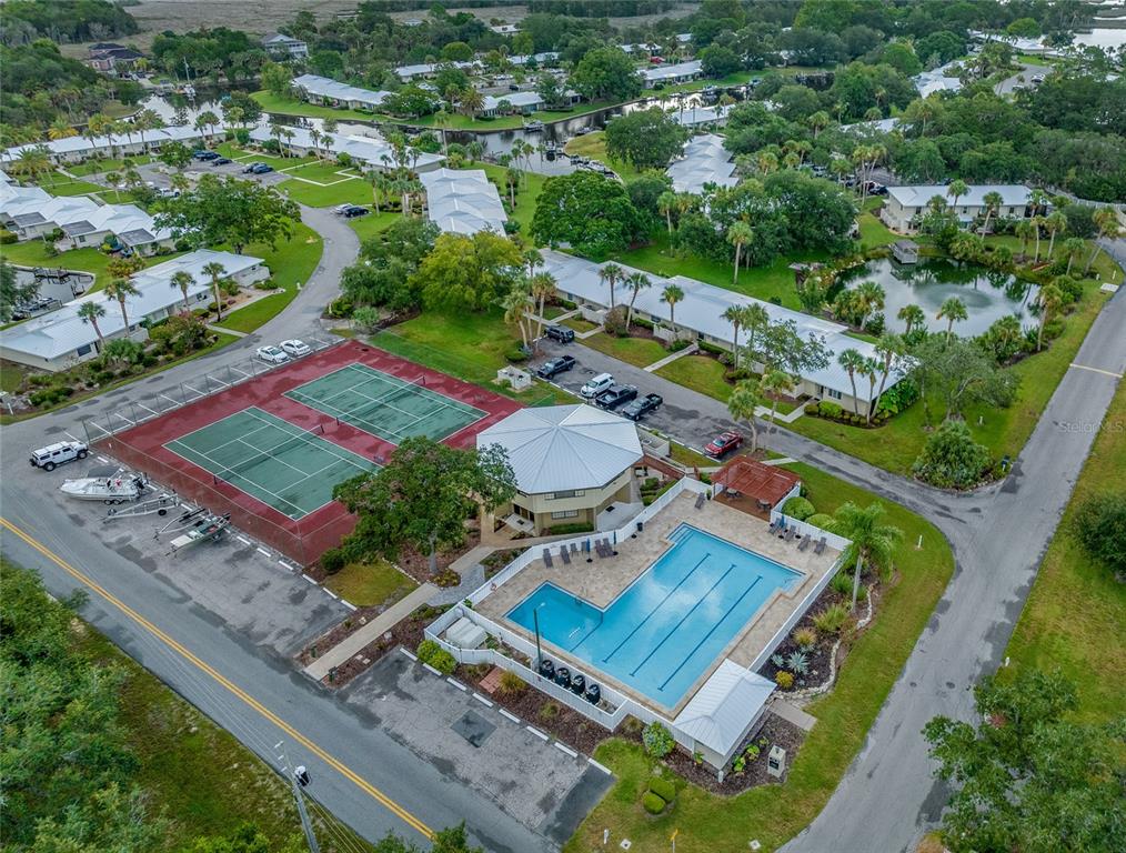 An aerial view shows a community with a swimming pool, tennis courts, and residential buildings — 11346 W BAYSHORE DRIVE UNIT 52, CRYSTAL RIVER, FL