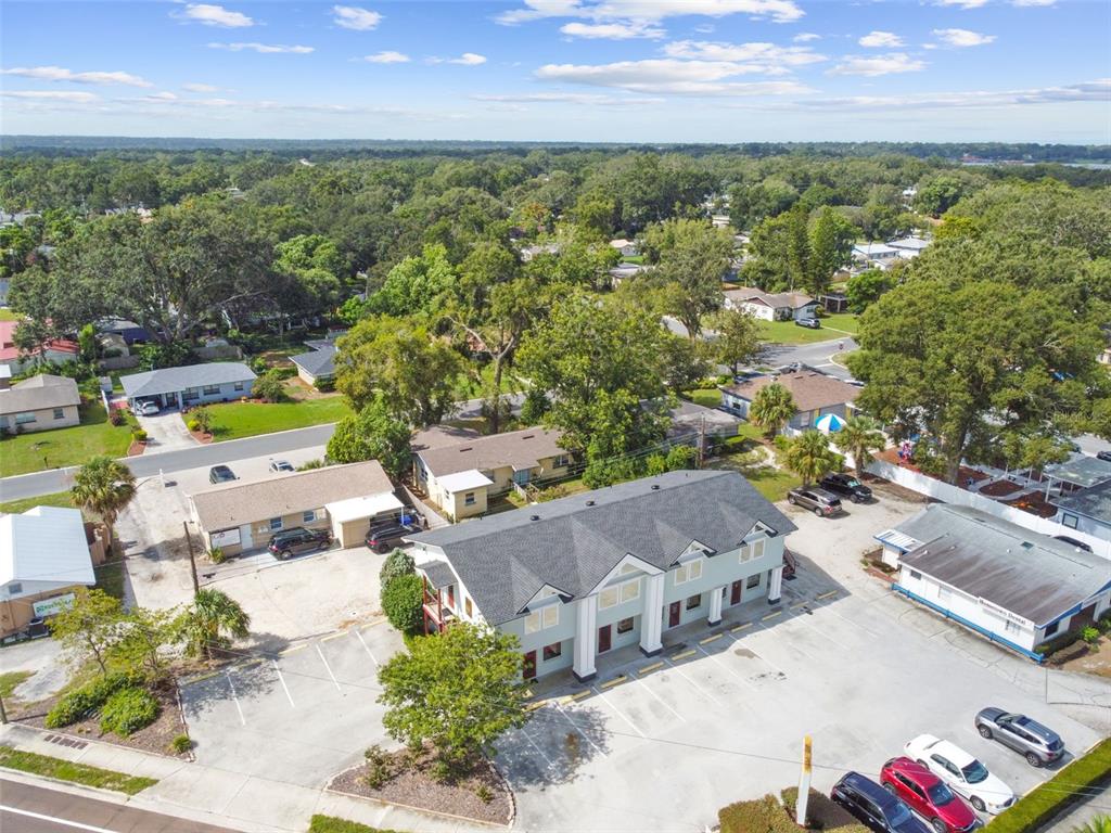 An aerial view shows a multi-unit commercial building with a parking lot and surrounding trees — 1137 BARTOW ROAD UNIT 205, LAKELAND, FL