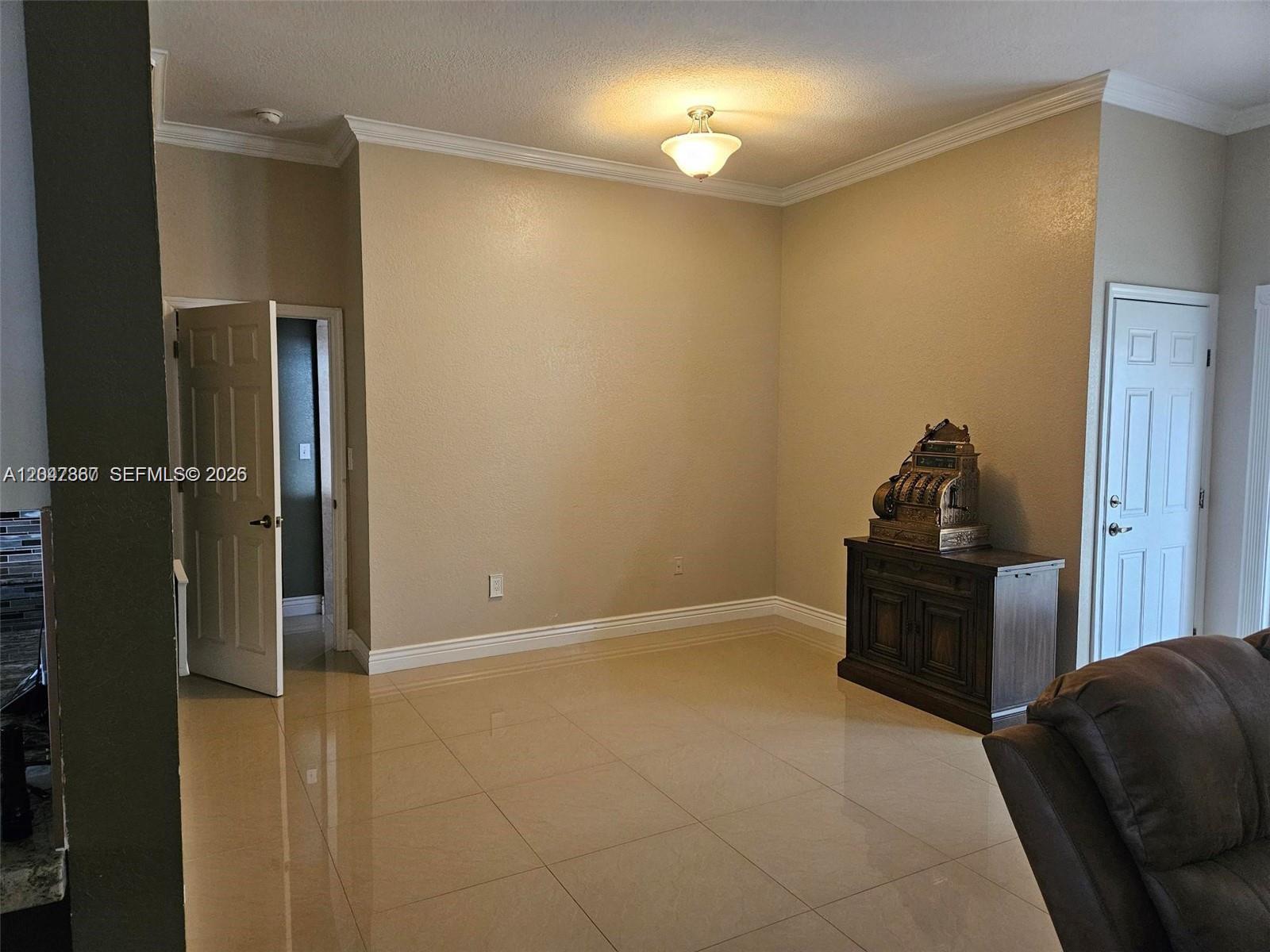 A room with beige walls, tile flooring, a ceiling light, and an antique cash register — 2635 SE 4th Pl, Homestead FL 33033, HOMESTEAD, FL