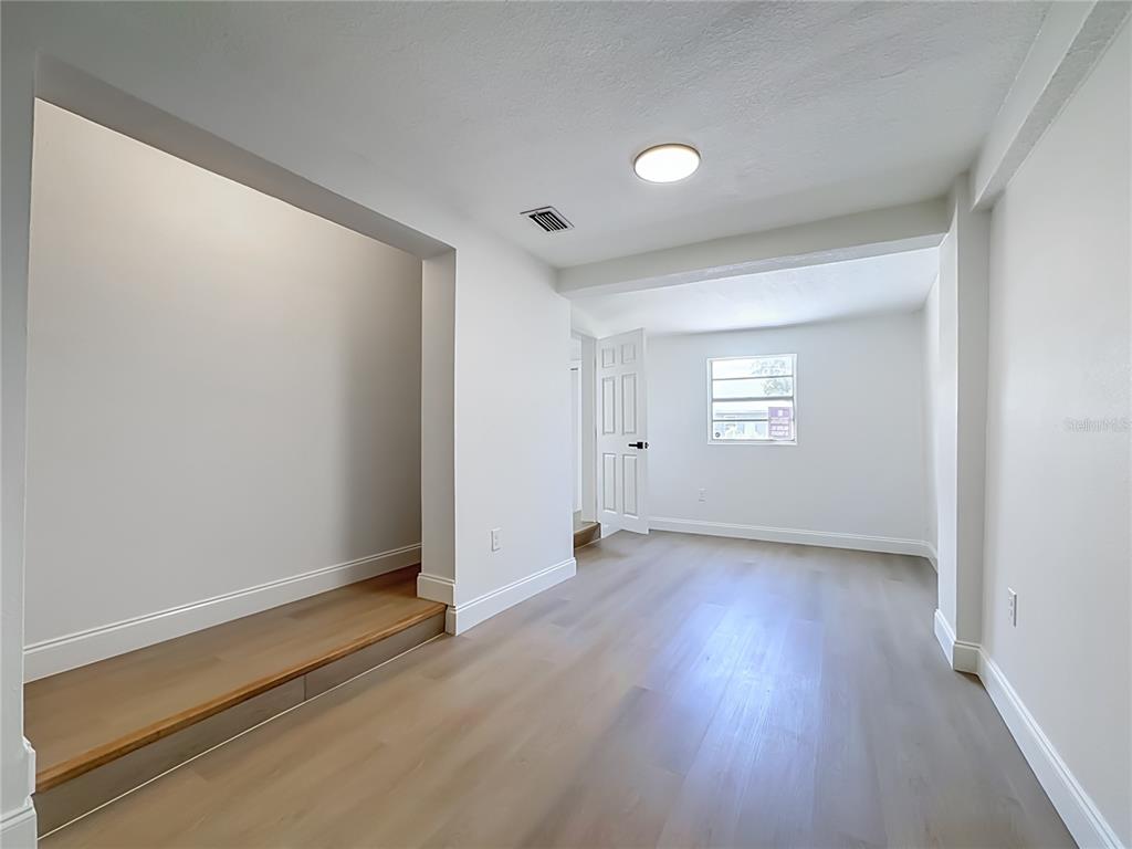 A room with light wood flooring, white walls, a recessed area, and a single window — 220 29TH STREET E, PALMETTO, FL