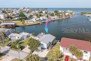 An aerial view shows a waterfront house with a dock and a boat lift — 14217 HENDRY COURT, HUDSON, FL