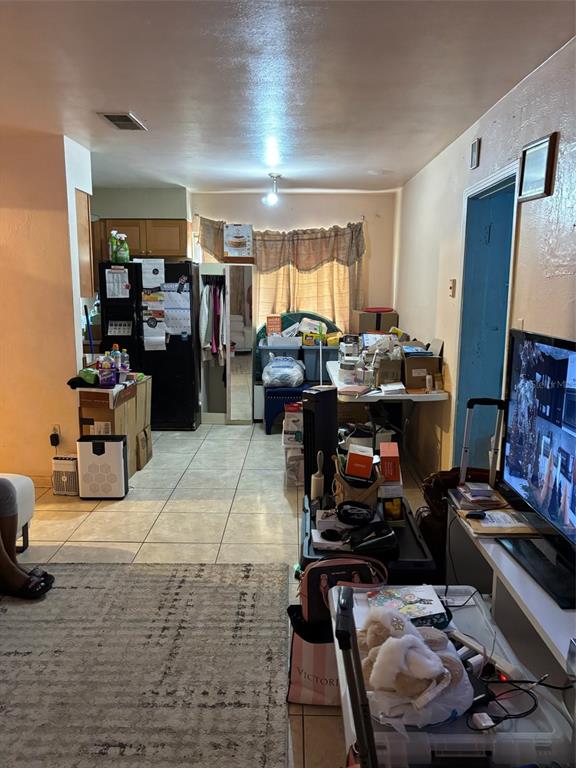 A living room with tile floors, a television, and various storage items and furniture — 1602 BREN LEE COURT, ORLANDO, FL