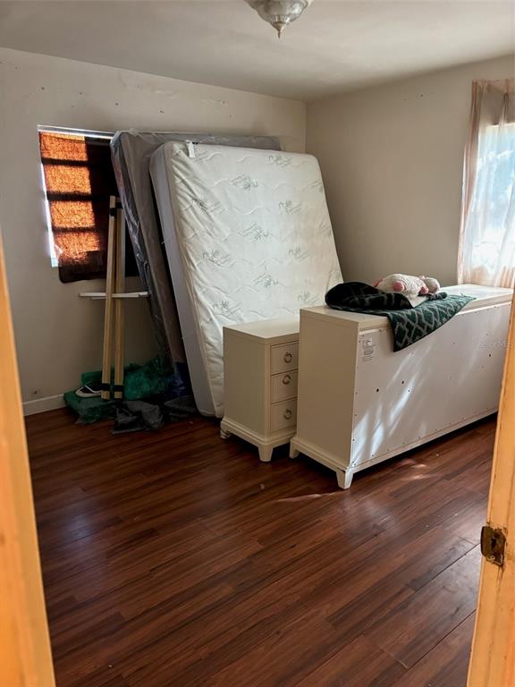 A bedroom features wood-look flooring, a mattress leaning against the wall, and white furniture — 1602 BREN LEE COURT, ORLANDO, FL