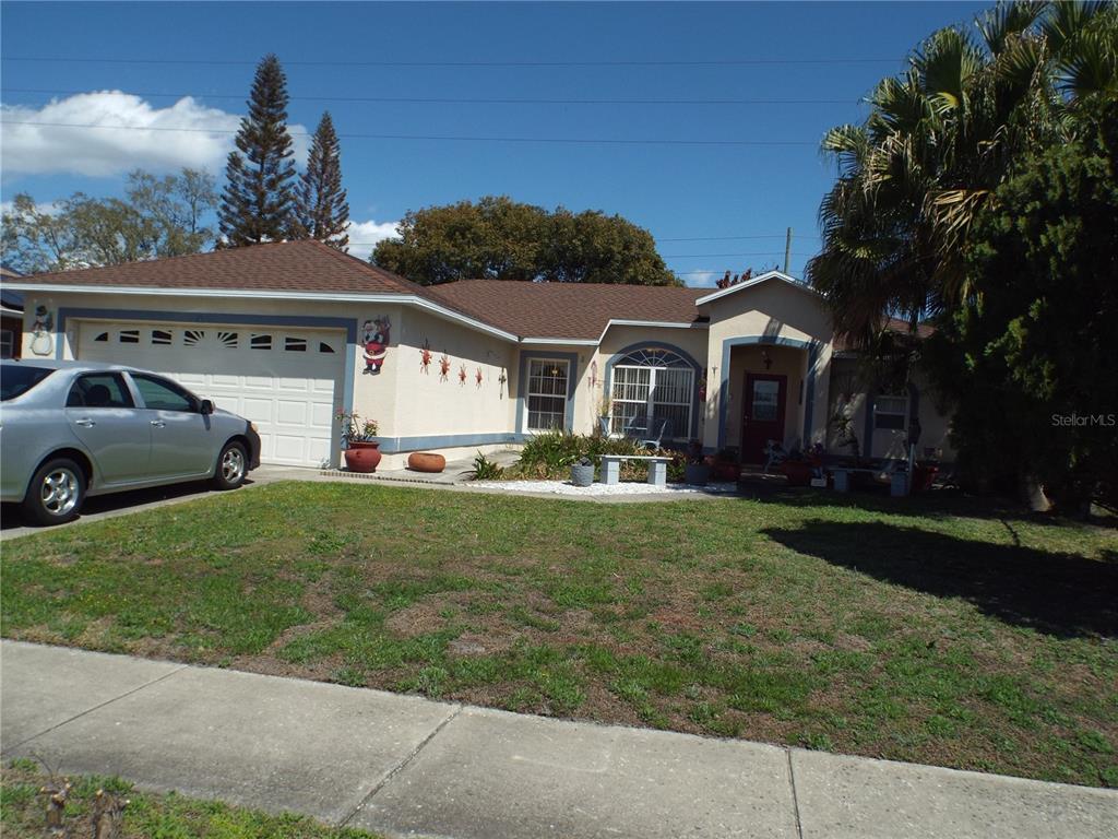 A single-story house with a two-car garage, beige stucco exterior, and a front lawn — 2546 SAGE DRIVE, KISSIMMEE, FL