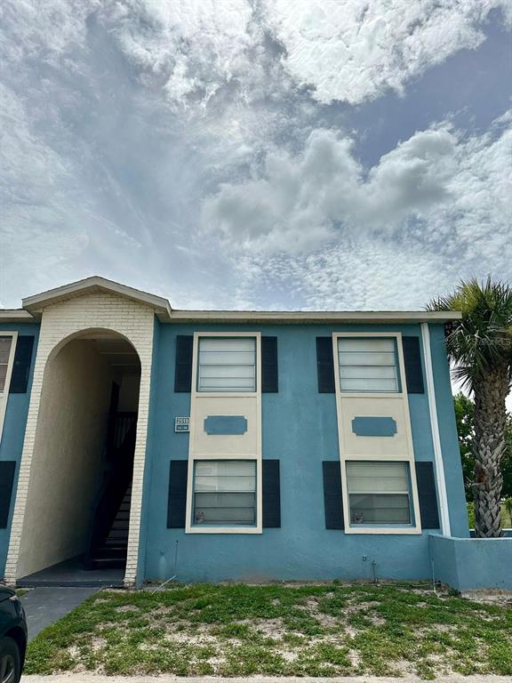 A two-story blue apartment building features an arched entryway and white-trimmed windows with black shutters — 2519 N ALAFAYA TRAIL UNIT 34, ORLANDO, FL