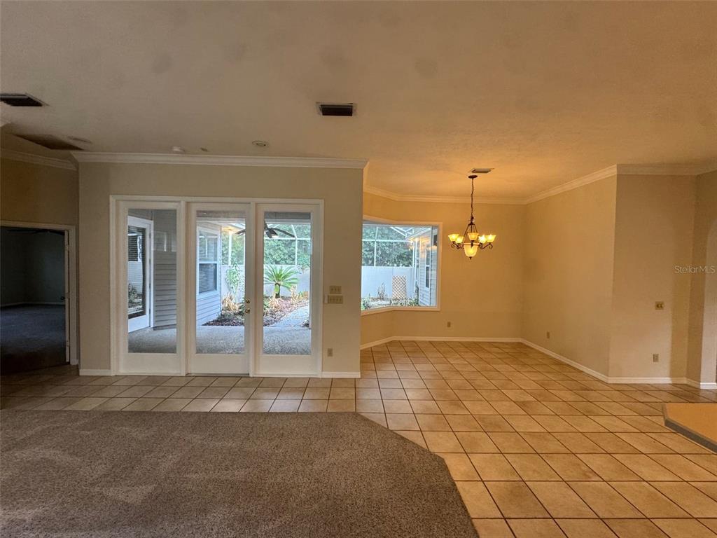 A dining area with tile flooring, a chandelier, and glass doors leading to a patio — 4404 SW 91ST DRIVE, GAINESVILLE, FL