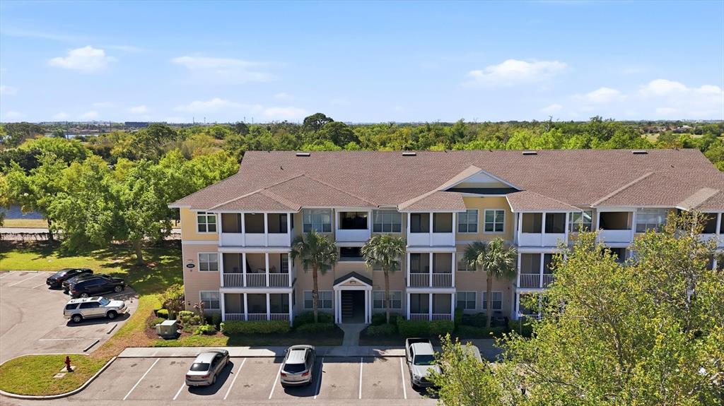 An aerial view of a three-story apartment building with a parking lot in front — 4802 51ST STREET W UNIT 1801, BRADENTON, FL