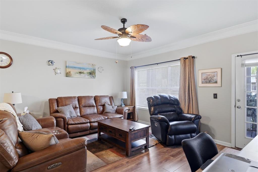 A living room features brown leather furniture, a wooden coffee table, and a ceiling fan — 4802 51ST STREET W UNIT 1801, BRADENTON, FL