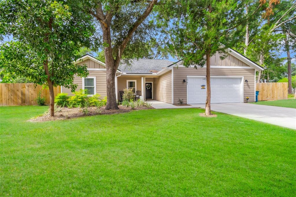 A single-story house with tan siding, a two-car garage, and a large front lawn — 23781 NW 193RD AVENUE, HIGH SPRINGS, FL