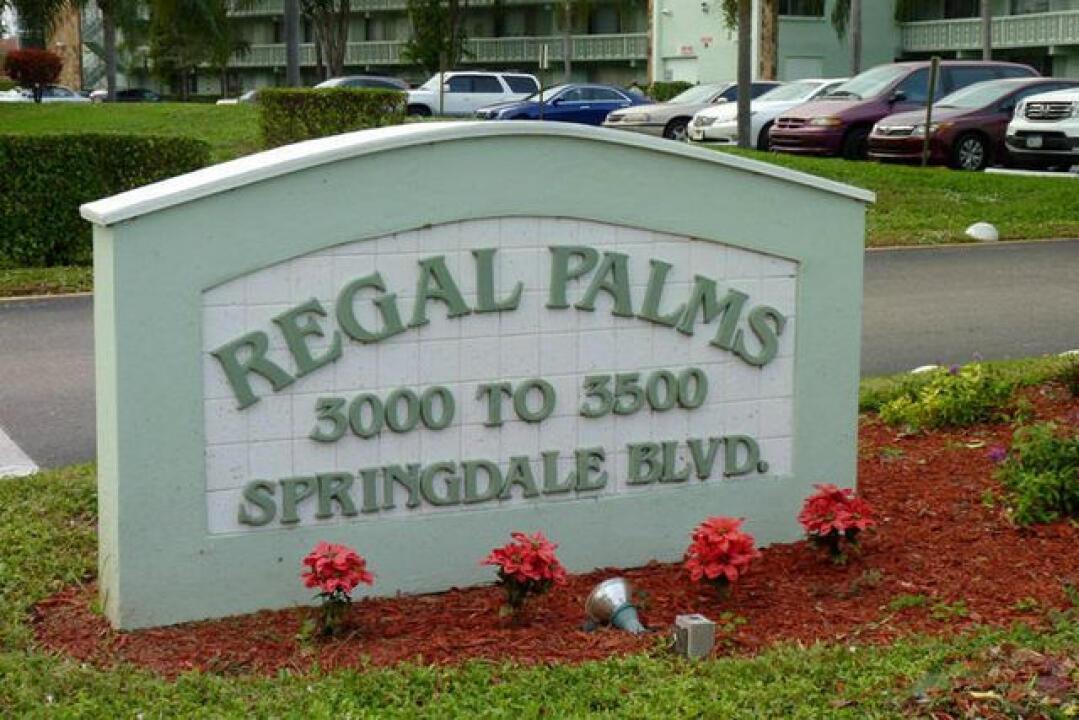 A light green sign for Regal Palms stands in front of a parking lot — 3300 Springdale Boulevard # 306, Palm Springs FL 33461, PALM SPRINGS, FL