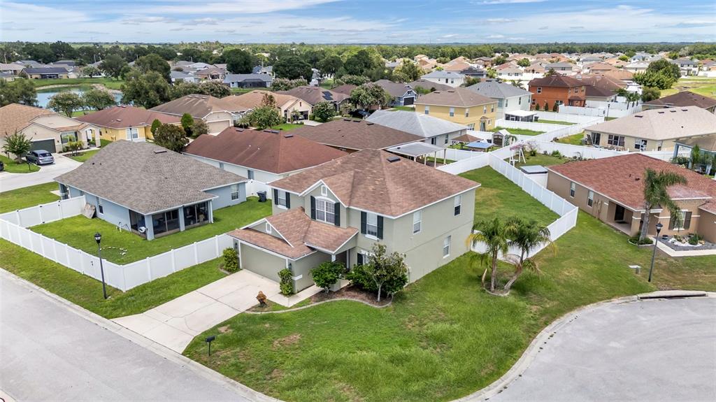 An aerial view shows a two-story suburban house with a brown roof and fenced yard — 3014 YARROW LANE, MULBERRY, FL