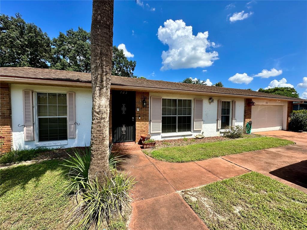 A single-story house with a white exterior, brick accents, and a front-facing garage — 723 GASTON FOSTER ROAD, ORLANDO, FL