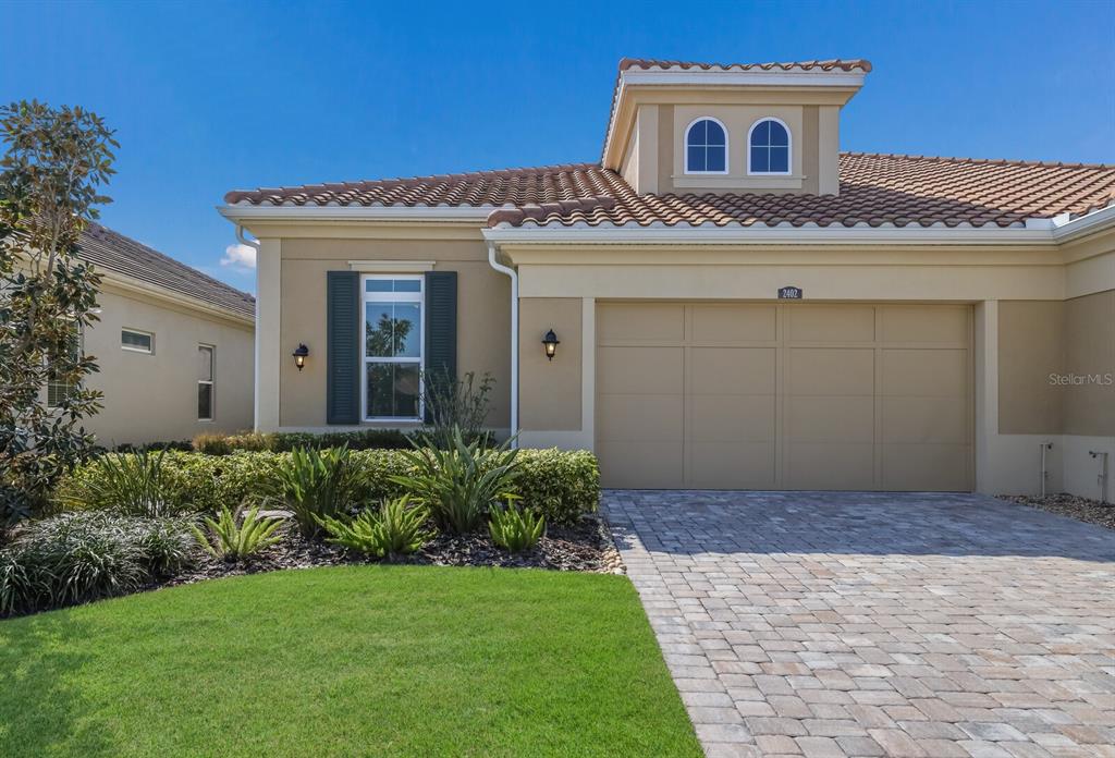 A stone monument sign with the name Arbor Grande stands in a grassy residential entrance — 2402 STARWOOD COURT, LAKEWOOD RANCH, FL