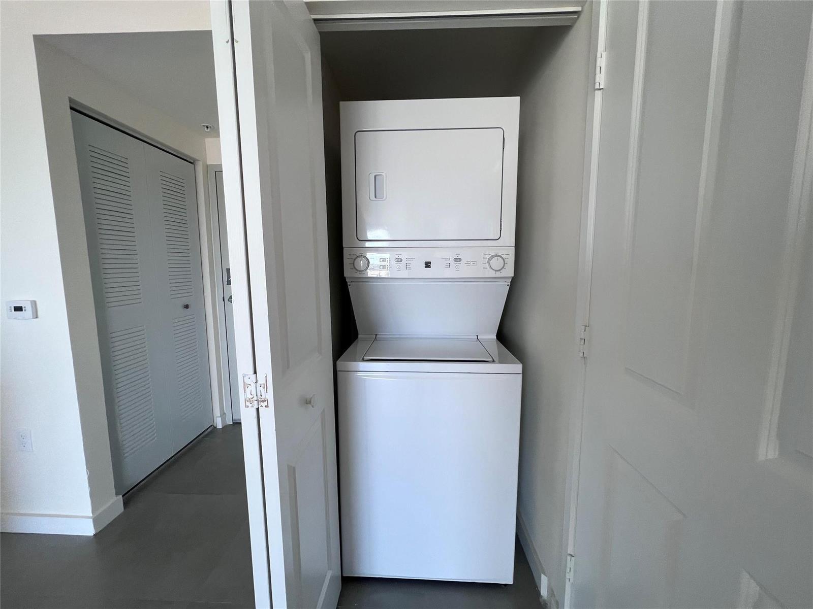 A white stacked washer and dryer unit is located inside a small closet — 729 NW 2 Street # 525, Miami FL 33128, MIAMI, FL