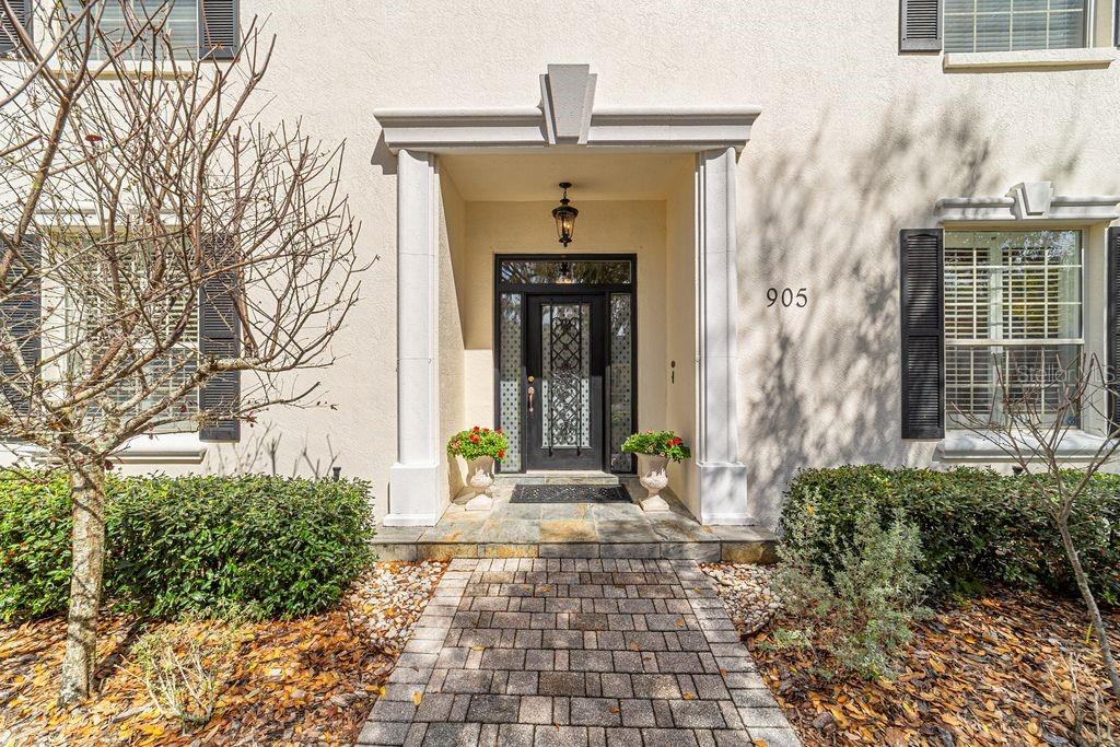 The exterior of a house features a stone walkway leading to a covered front entrance — 905 SE 12TH STREET, OCALA, FL