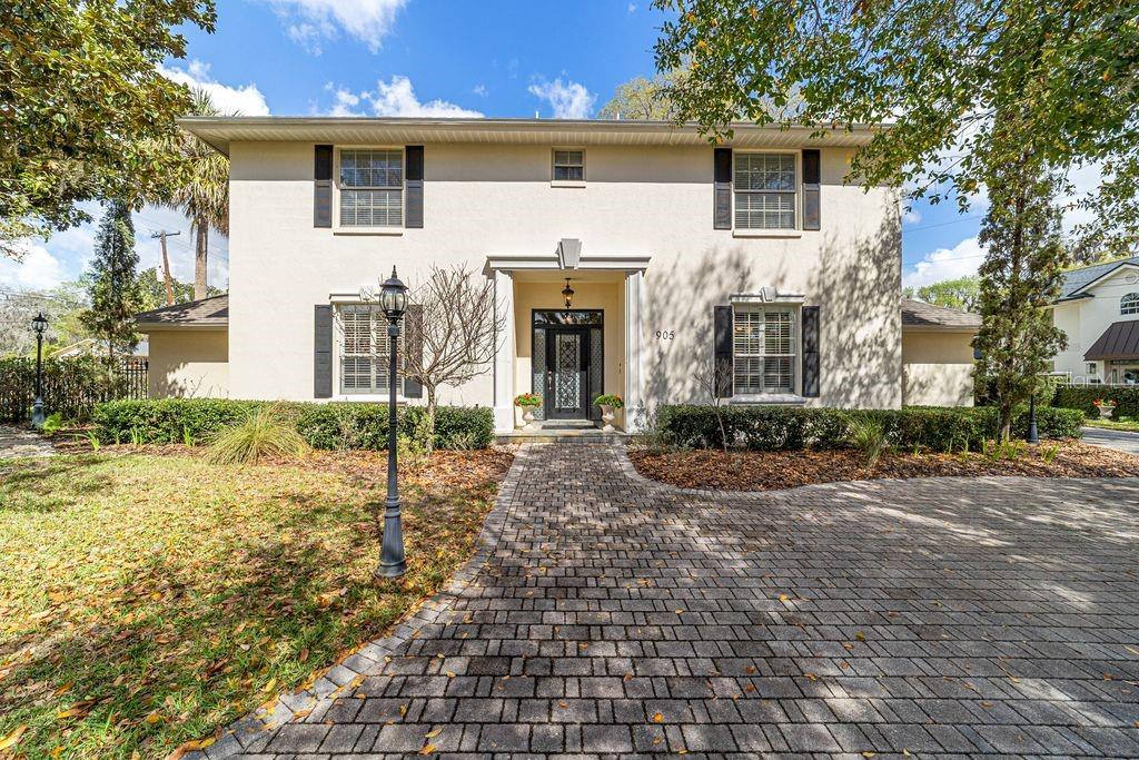 A two-story stucco house features a brick walkway leading to a central front entrance — 905 SE 12TH STREET, OCALA, FL