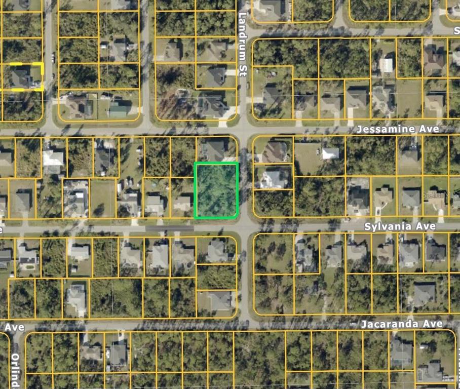 This is an aerial map showing a vacant, wooded residential lot highlighted in green — SYLVANIA AVENUE, NORTH PORT, FL