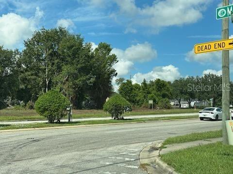A view of a vacant lot with trees and a dead-end street sign — 000 HOWLAND BLVD & BLUFFVIEW BOULEVARD, DELTONA, FL