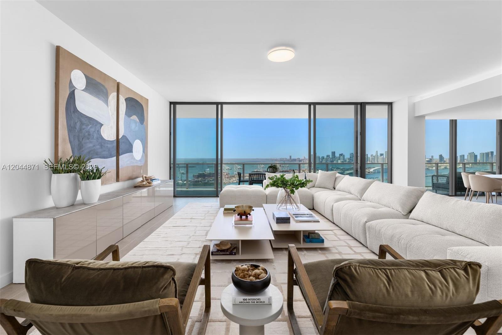 A modern living room features a large sectional sofa, two armchairs, and floor-to-ceiling windows — 501 West Ave # 4102, Miami Beach FL 33139, MIAMI BEACH, FL