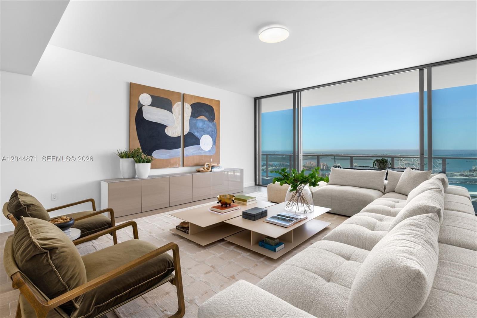 A modern living room features a beige sectional, two olive armchairs, and floor-to-ceiling windows — 501 West Ave # 4102, Miami Beach FL 33139, MIAMI BEACH, FL
