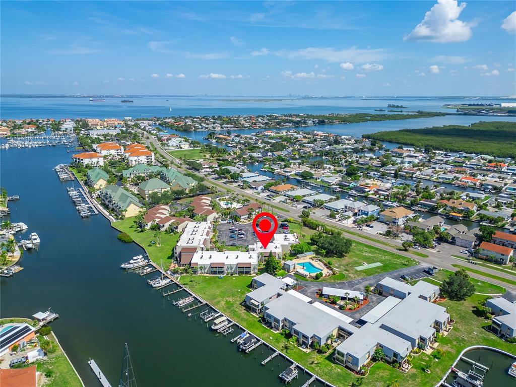 An aerial view shows a waterfront residential complex with a pool and boat slips — 1028 APOLLO BEACH BOULEVARD UNIT 104, APOLLO BEACH, FL