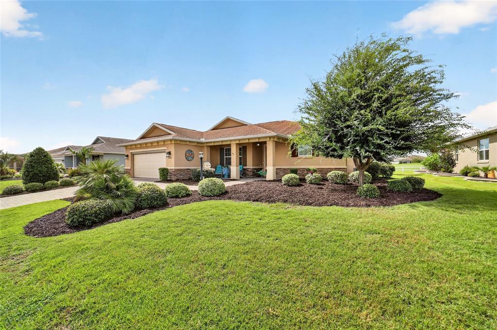 A single-story house with a tan exterior, a two-car garage, and a landscaped front yard — 9200 SW 85TH PLACE, OCALA, FL