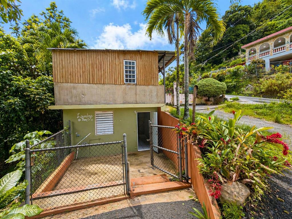 A two-story building features a ground-level laundry room with a fenced patio area — R517 COLLORES WARD, JUANA DIAZ, PR