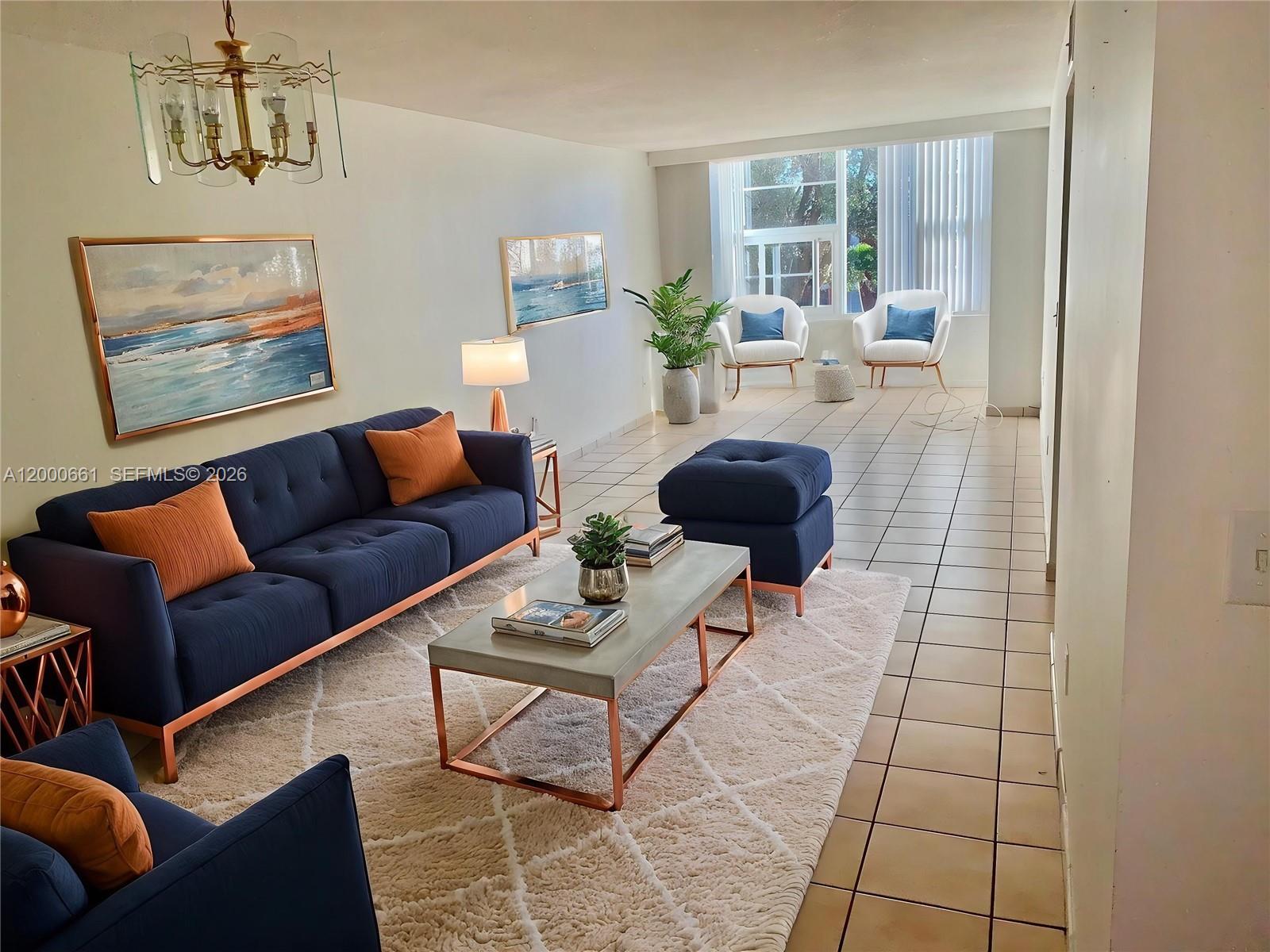 A living room features a blue sofa, a concrete coffee table, and tiled flooring — 7345 W 4th Ave # 203, Hialeah FL 33014, HIALEAH, FL