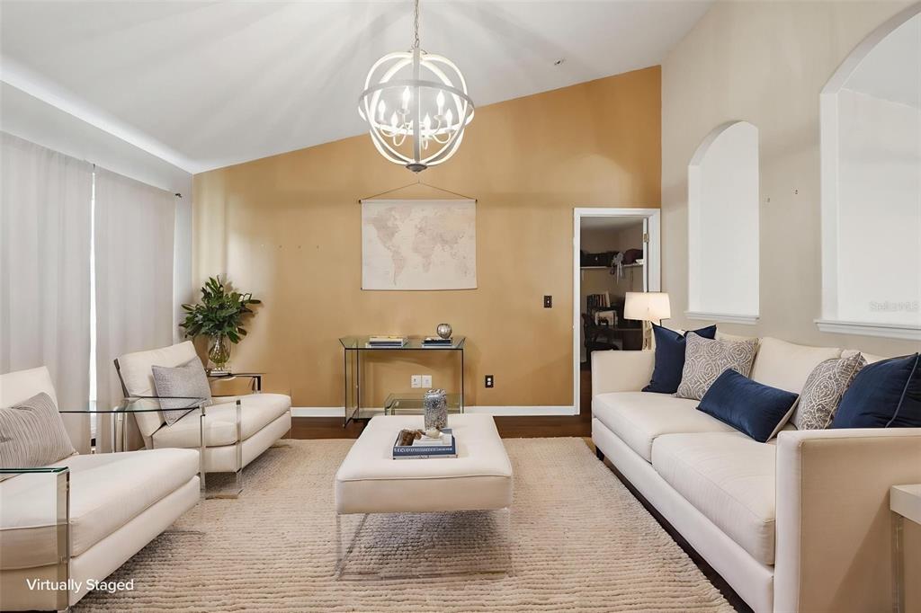 A living room features a vaulted ceiling, a chandelier, and white furniture on a rug — 5341 BIRCHWOOD ROAD, SPRING HILL, FL