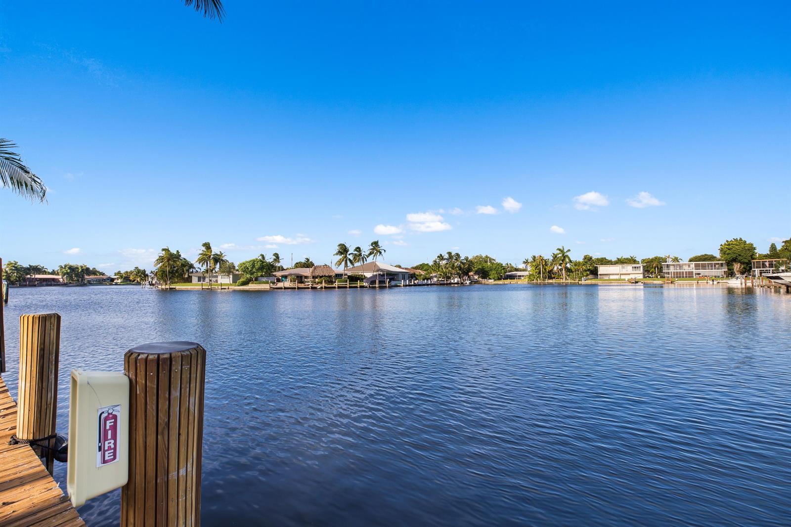 A wooden dock with a fire extinguisher overlooks a canal lined with waterfront homes — 1400 SE 7th Avenue # 2, Pompano Beach FL 33060, POMPANO BEACH, FL