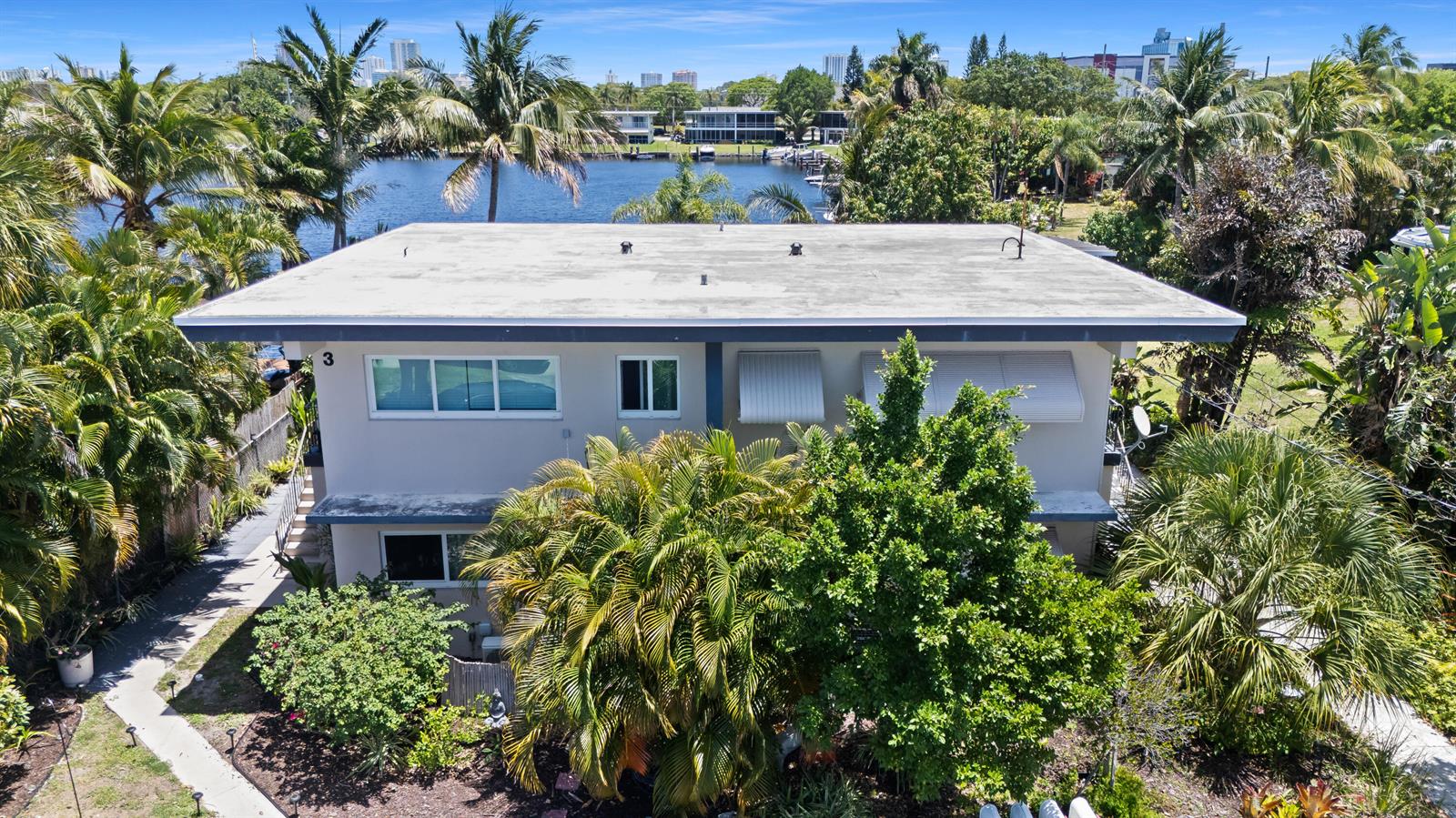 An exterior view of a two-story apartment building with a flat roof and palm trees — 1400 SE 7th Avenue # 2, Pompano Beach FL 33060, POMPANO BEACH, FL