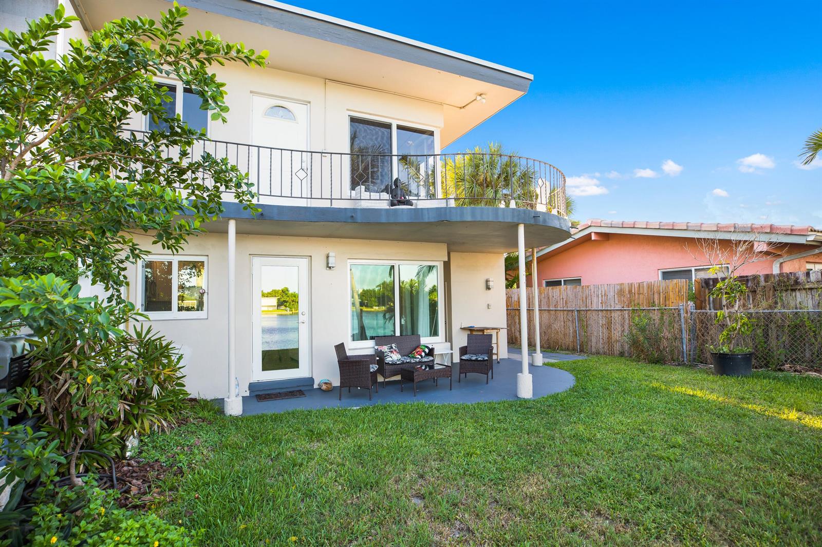 A two-story house exterior with a balcony, patio furniture, and a grassy backyard — 1400 SE 7th Avenue # 2, Pompano Beach FL 33060, POMPANO BEACH, FL