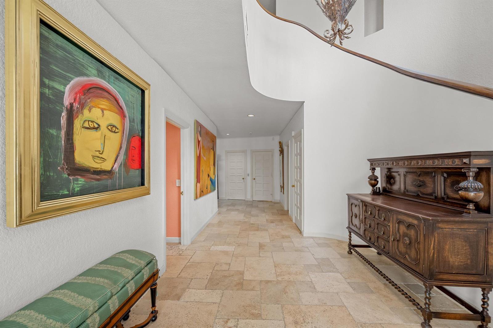 A hallway with tile flooring, a wooden sideboard, and artwork on the walls — 23 Sloans Curve Drive, Palm Beach FL 33480, PALM BEACH, FL