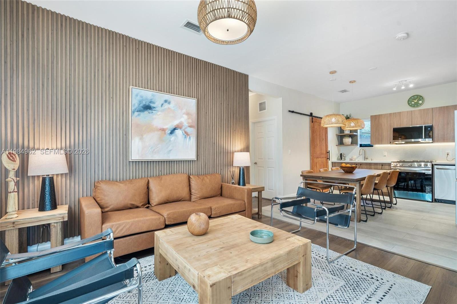 A living room and dining area feature a wood-slatted accent wall and leather sofa — 920 SW 9th St, Miami FL 33130, MIAMI, FL