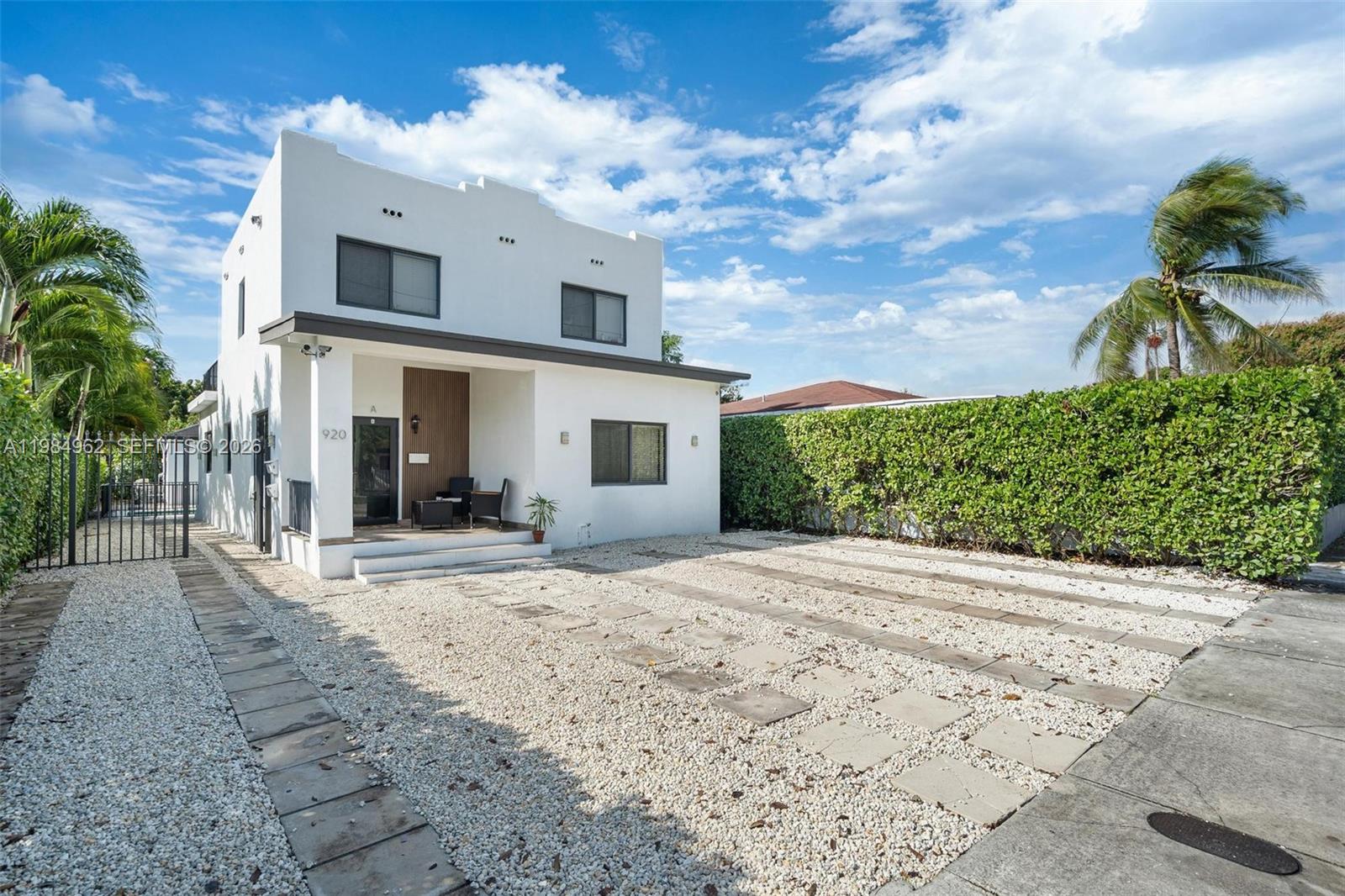 A two-story white house features a gravel driveway with stone pavers and a tall hedge — 920 SW 9th St, Miami FL 33130, MIAMI, FL