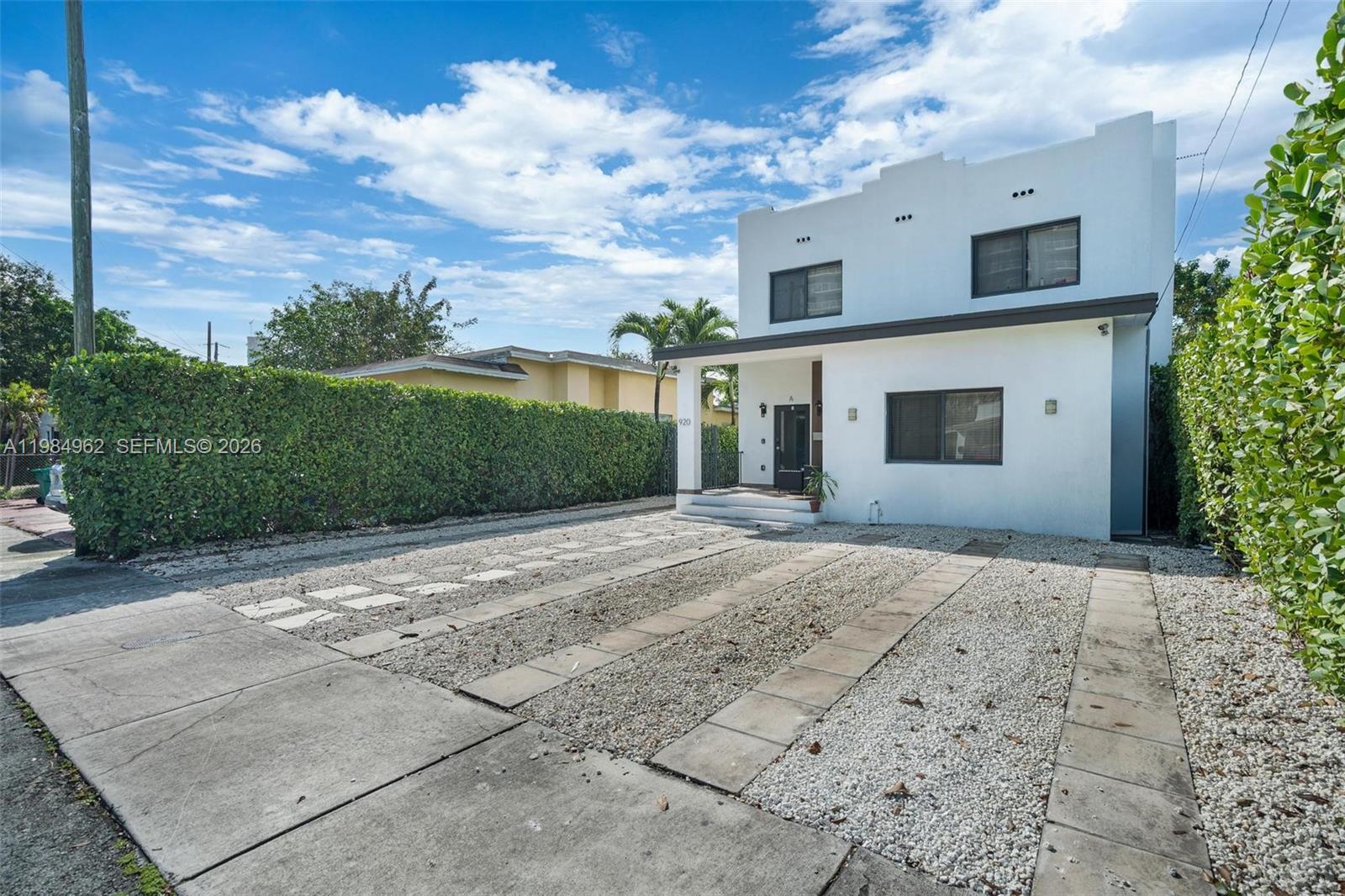 A two-story white house features a gravel driveway with concrete tire tracks and hedges — 920 SW 9th St, Miami FL 33130, MIAMI, FL