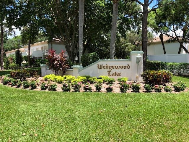 A stone monument sign for Wedgewood Lake sits in a landscaped garden with trees — 5226 MARSH FIELD LANE UNIT 11, SARASOTA, FL