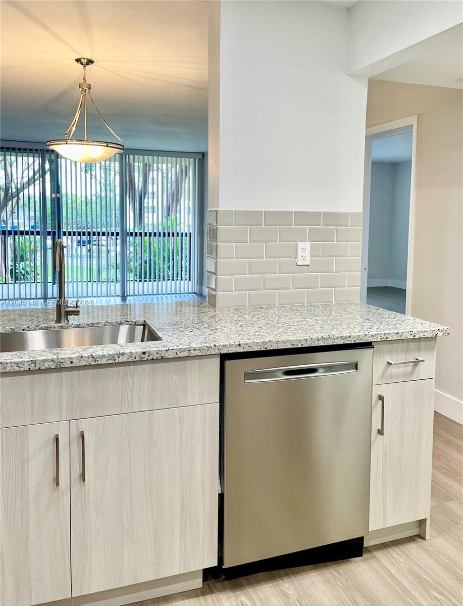 A kitchen features light wood cabinets, granite countertops, a stainless steel dishwasher, and subway tile backsplash — 10835 SW 112th Ave # 212, Miami FL 33176, MIAMI, FL