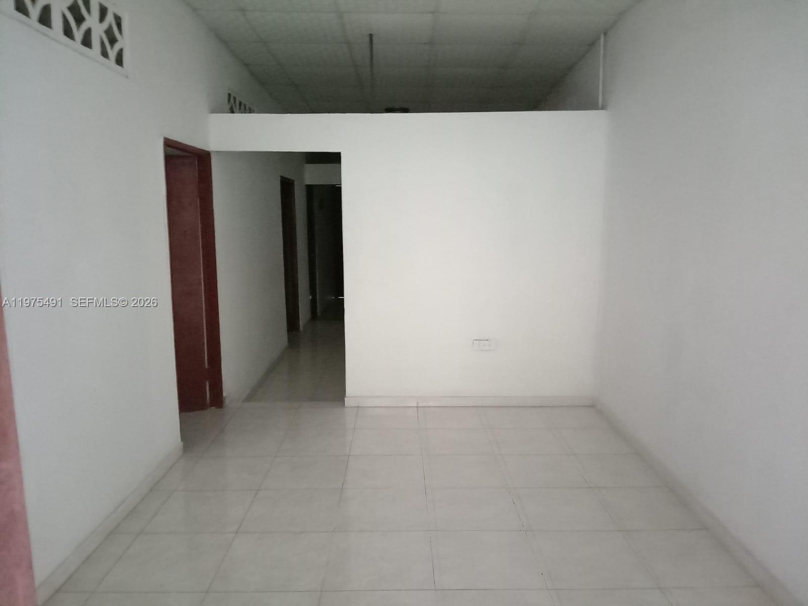 An empty room with white walls, tiled flooring, and a doorway leading to a hallway — 4150 SANTA CLARA, ou N/A, ou