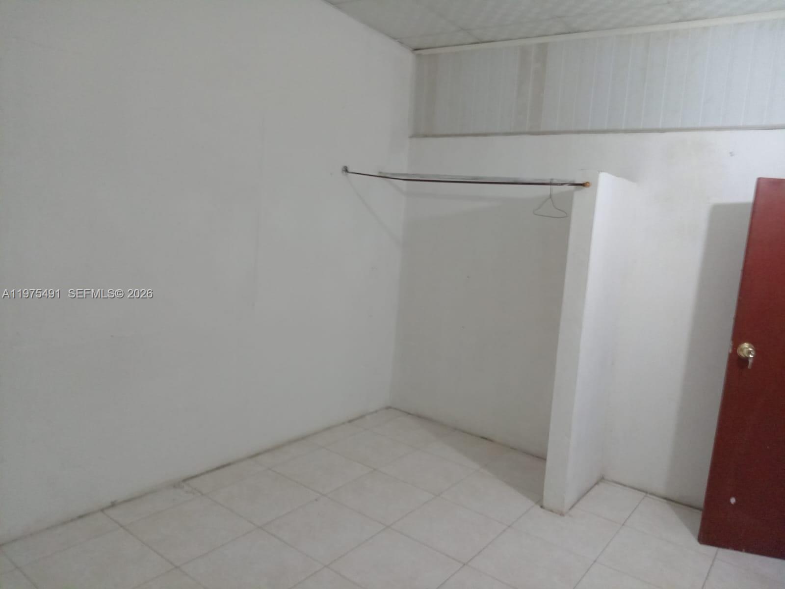 A small room features white walls, a tiled floor, and a metal clothing rod — 4150 SANTA CLARA, ou N/A, ou