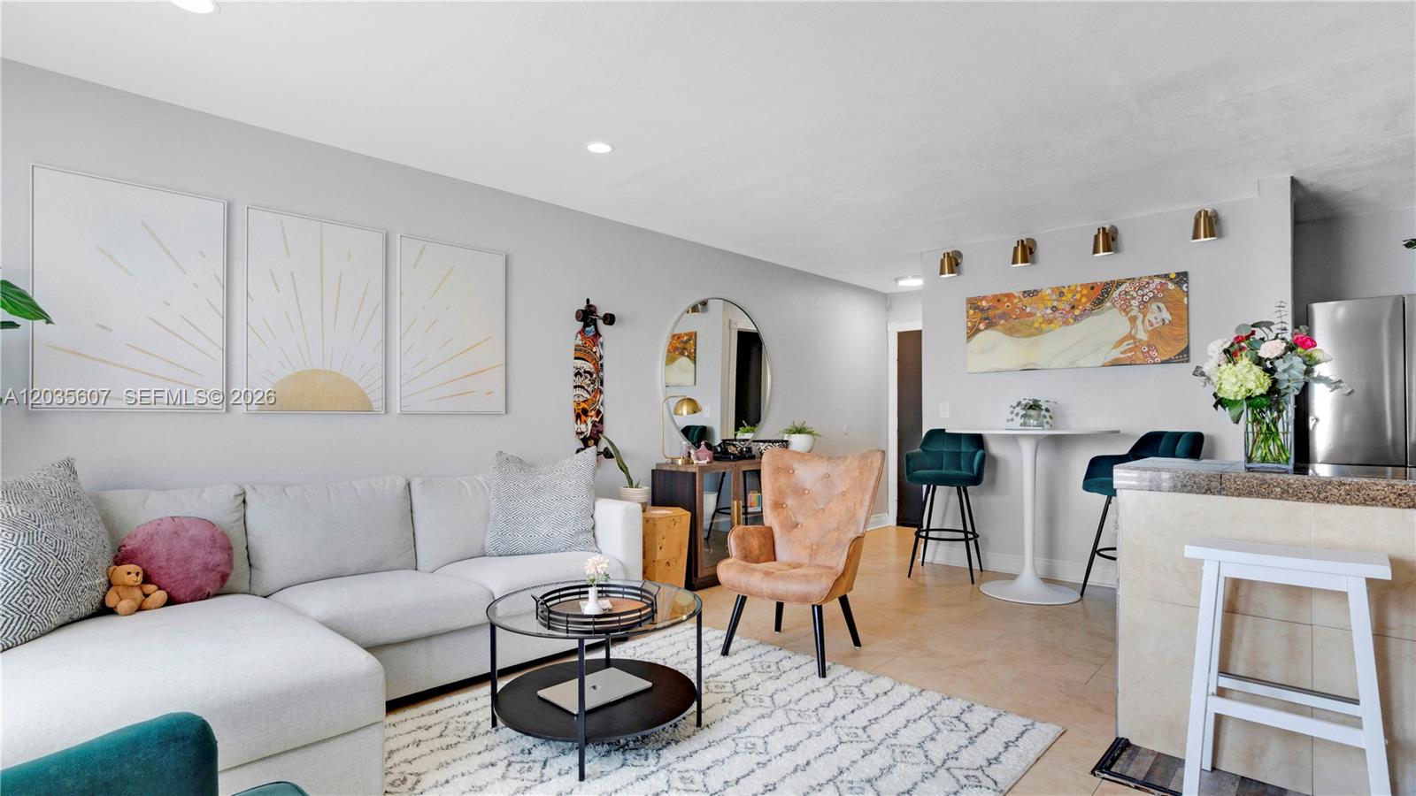 A living room features a light gray sectional sofa, a round coffee table, and a dining area — 7925 Carlyle Ave # 403, Miami Beach FL 33141, MIAMI BEACH, FL
