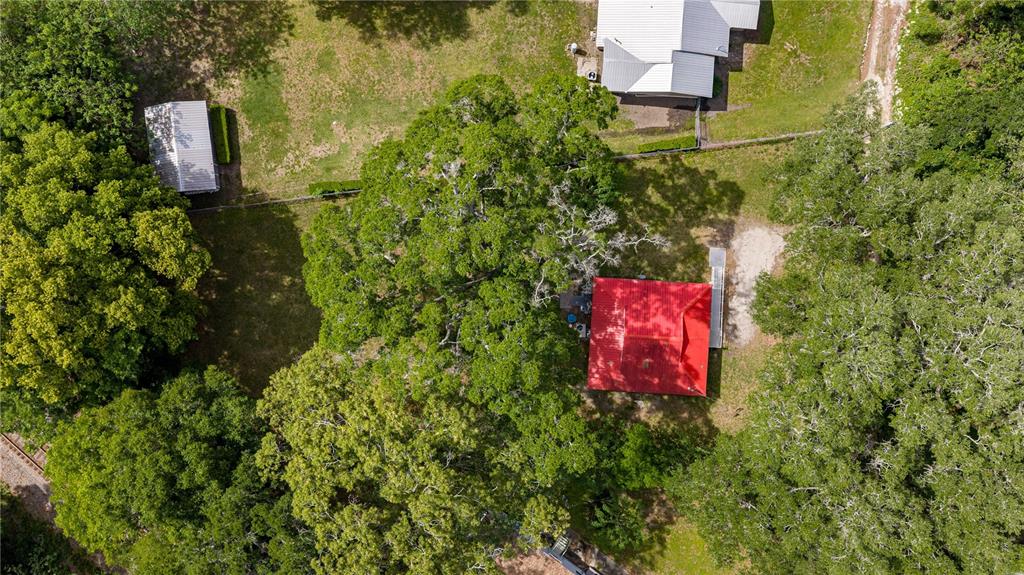 An aerial view shows a house with a red roof surrounded by large trees — 3331 SE 11TH AVENUE, OCALA, FL