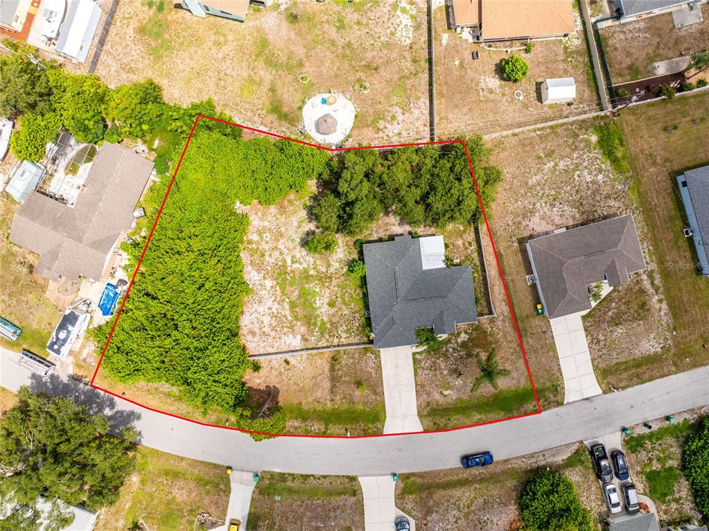 An aerial view shows a residential lot with a house, driveway, and surrounding trees — 11082 VANESSA AVENUE, ENGLEWOOD, FL