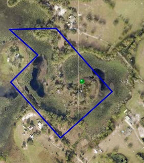 An aerial map shows a property boundary outlined in blue over a wooded, marshy area — 44750 MISTY ISLE DRIVE, DELAND, FL