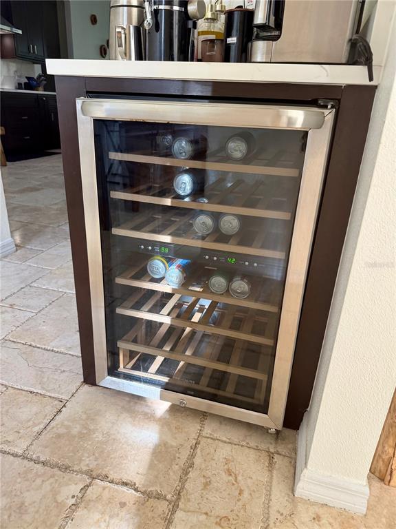 A built-in wine refrigerator with wooden shelves is installed under a white countertop — 1584 SHADOWMOSS CIRCLE, LAKE MARY, FL