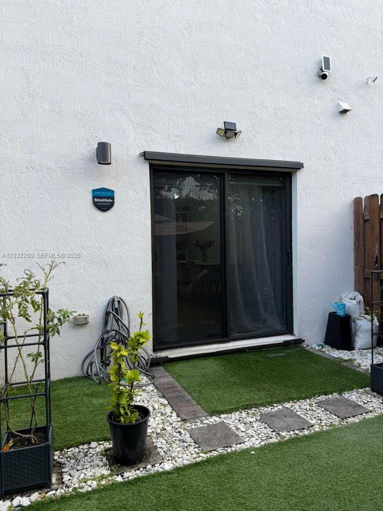 A sliding glass door leads to a small patio with artificial turf and white gravel — 20731 NE 7th Pl # 20731, Miami FL 33179, MIAMI, FL